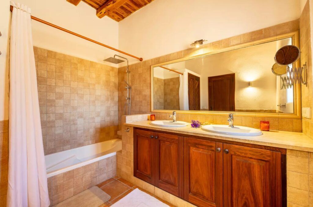 Baño del dormitorio 3 con bañera y doble lavabo en Sa Païssa den Botja Ibiza