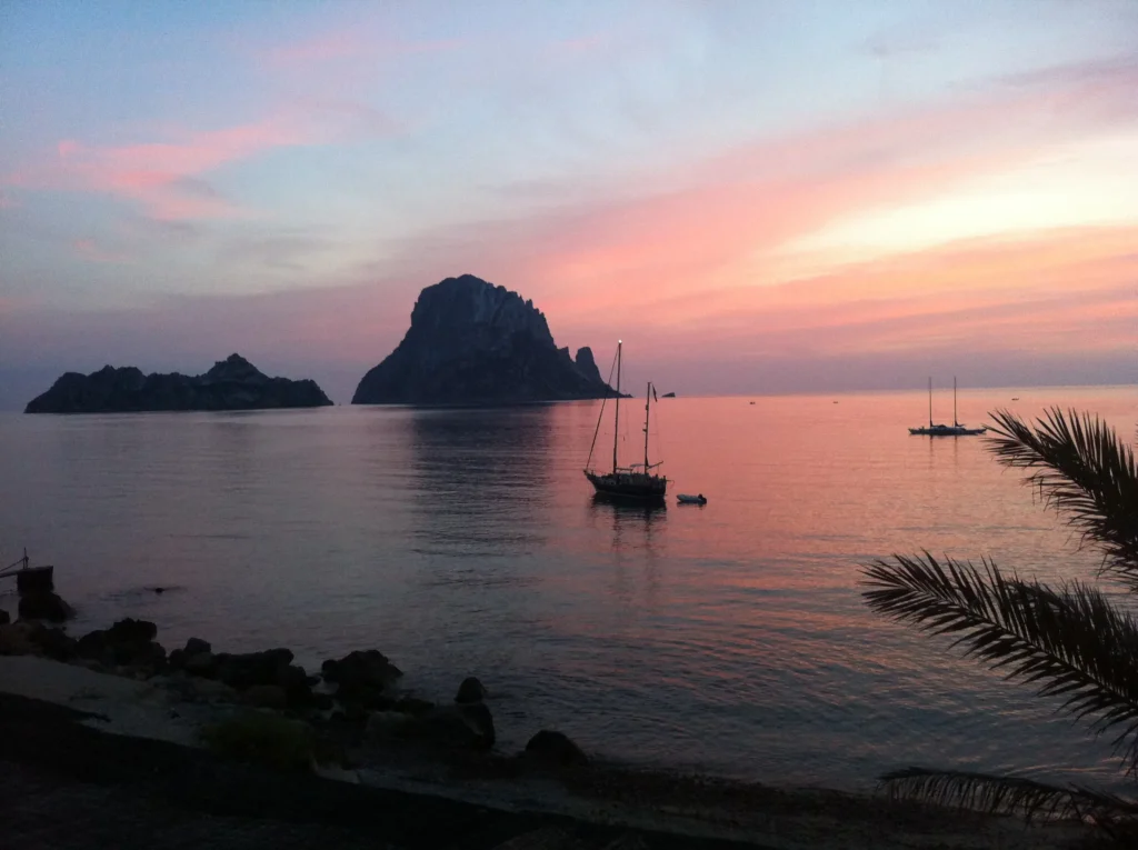 Atardecer rosado frente a Es Vedrà desde la costa de Cala D'Hort