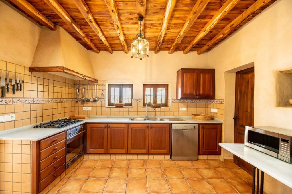 Cocina de la casa Sa Païssa con techo de madera en Cala Carbó Ibiza