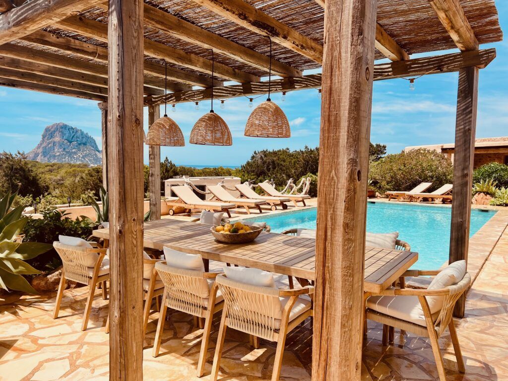 Comedor exterior frente a la piscina con vistas a Es Vedrà en Sa Païssa den Botja Ibiza