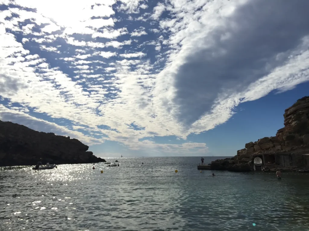 Cielo con nubes sobre Cala Carbó y paisaje costero de Ibiza