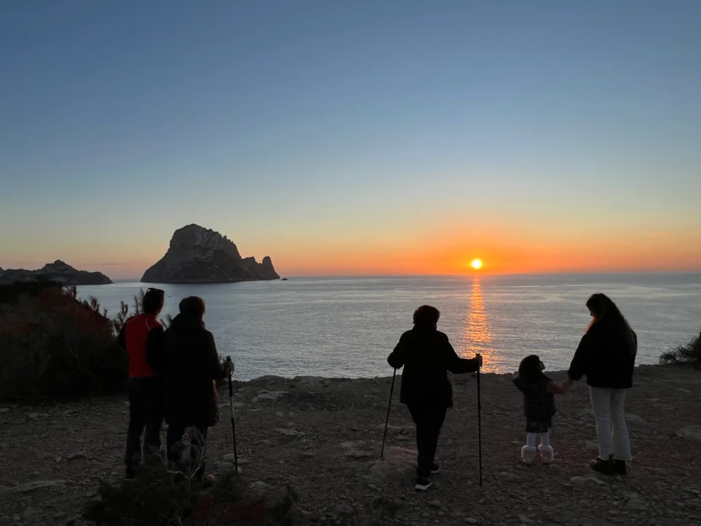Vista del atardecer en mirador de Cala d´hort con Es Vedrà y personas en la orilla