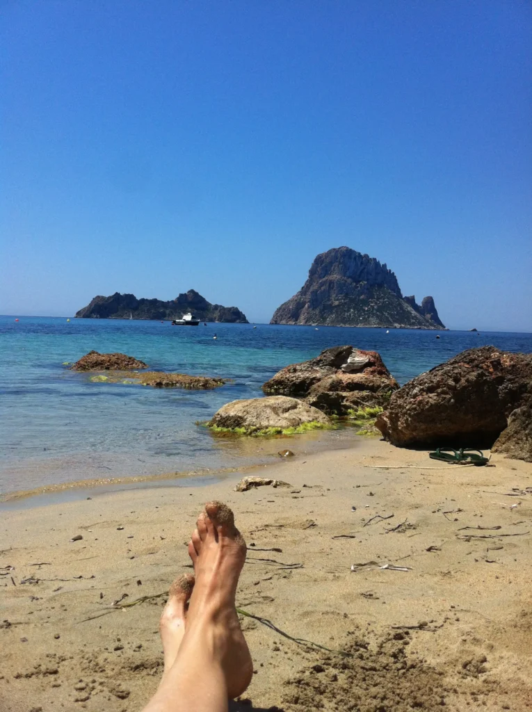 Playa de Cala Carbó con aguas turquesas y Es Vedrà al fondo, Ibiza